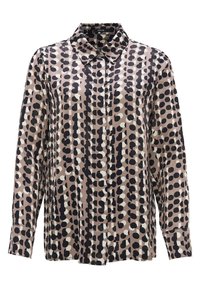 Blouse à manches longues boutonnée avec un motif de points irréguliers noirs et blancs sur fond beige, avec un col pointu et des manches avec poignets.