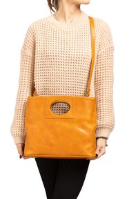 Tasche aus braunem Leder mit strukturierter Oberfläche, ausgestattet mit einem Ausschnitt-Griff und einem verstellbaren Schultergurt. Kompakte rechteckige Form.