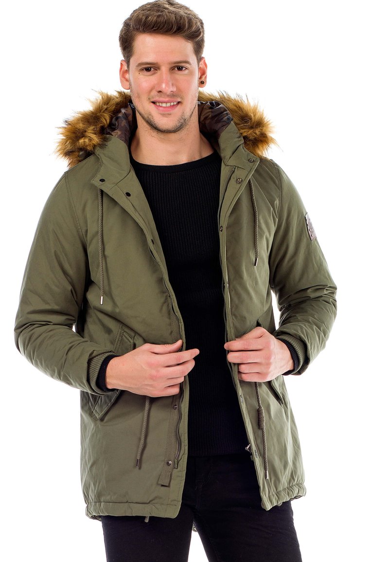 Grüne isolierte Jacke mit einer Kapuze aus Kunstfell. Merkmale sind ein Reißverschluss vorne, Seitentaschen und ein Kordelzug am Saum. Strukturierter Stoff, lässige Passform.