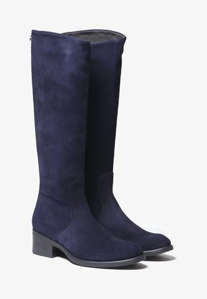 Botas de ante azul marino hasta la rodilla con un diseño elegante, suela de goma negra y detalles de costura sutiles a lo largo de las costuras.