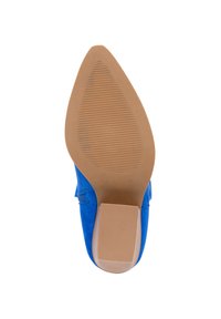 Zapato azul de ante con punta afilada, suela texturizada y tacón de altura media. La base es de color marrón claro con líneas de agarre horizontales.