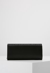 Pochette en cuir noir avec un dessus grisé pailleté. Forme rectangulaire avec une texture lisse, dotée d'une fermeture éclair et d'un subtil détail de couture.