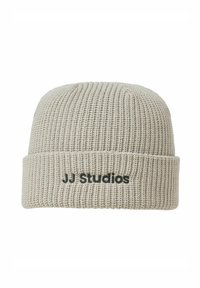 Gorro de punto en un tono beige claro con textura acanalada. Cuenta con un dobladillo con detalle del logotipo negro "JJ Studios".