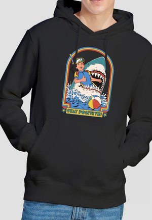 Boy in snorkeling gear gives thumbs up near open-mouthed shark and beach ball, with text "Stay Positive!" on black hoodie.