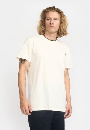Beige Rundhalsausschnitt-T-Shirt aus Baumwolle mit einer Brusttasche und kurzen Ärmeln. Zeigt ein dezentes Logo auf der Tasche.