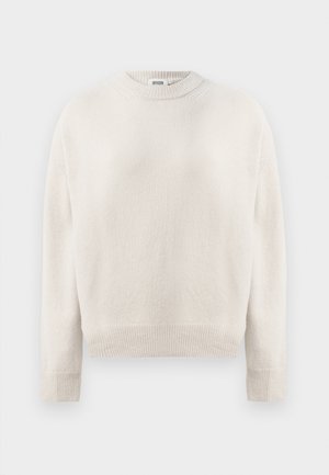 Cremefarvet strikket sweater med lange ærmer, ribbede manchetter, kant og rund halsudskæring, mærket "DRYKORN" inden i kraven.