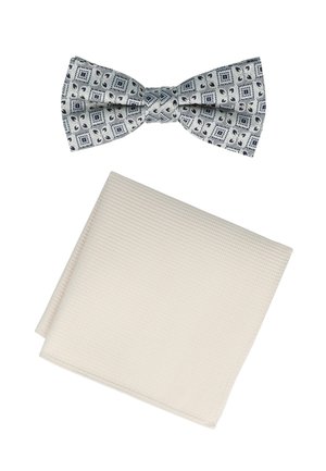 Navy and white patterned bow tie with geometric design above a textured cream cotton pocket square, folded with clean edges.