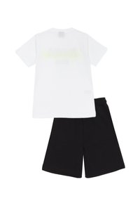 T-shirt bianca in cotone con un design semplice e una grafica leggera, abbinata a pantaloni corti neri in cotone con un elastico in vita.