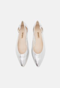 Srebrne metaliczne baletki z wydłużonym noskiem, regulowanym paskiem oraz gładką fakturą. Wewnątrz znajduję się beżowa miękka wkładka.