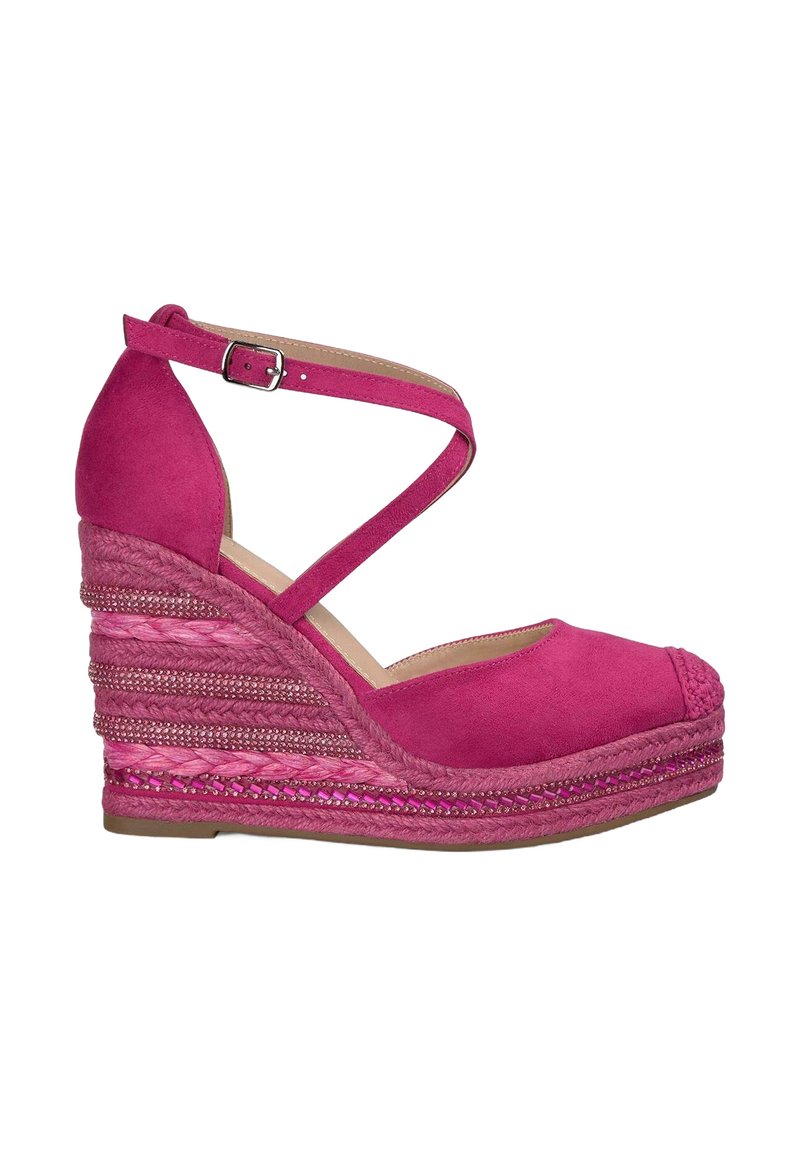 Sandali con tacco a cuneo in suede fucsia, con cinturini incrociati alla caviglia. Dettaglio in juta intrecciata su una piattaforma simile alla paglia, decorata con piccoli elementi metallici.