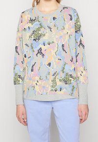 Mönstrad sweatshirt i flera färger med ljusgrå krage och mudd. Har en blandning av pastellfärger och abstrakta mönster. Mjuk textur.
