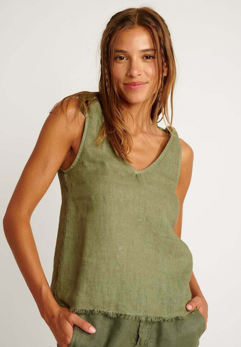Top in lino verde con scollo a V, dal taglio morbido, dettagli con orlo sfilacciato e spalline regolabili.