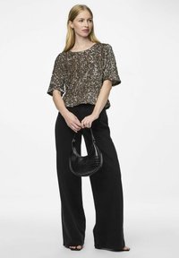 Top corto con lentejuelas marrones y corte holgado, combinado con pantalones anchos negros y un pequeño bolso negro con estampado de cocodrilo.