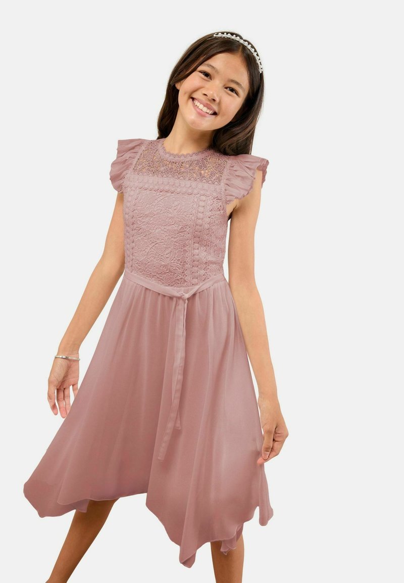 Púderrózsaszín ruha csipke felsőrésszel és fodros, rövid ujjakkal, deréknál azonos színű szalaggal megkötve. Lenge, A-vonalú szoknya.