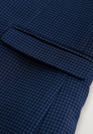 Material texturat albastru închis cu un model mic de carouri. Are un buzunar cusut cu atenție și o margine pliată cu precizie.