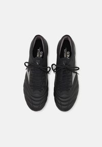 Scarpe da calcio nere con tomaia in materiale sintetico testurizzato, punta rotonda, linguetta imbottita e lacci tonali. Presenta il marchio bianco sui lati.