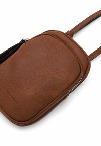 Brown leather crossbody bag with a textured surface, rounded shape, zip closure, and a flat strap for carrying.