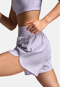 Lyse lilla atletikshorts med elastisk linning, sidelommelynlås og buet kant, lavet af fugttransporterende stof.