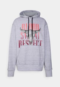 Světle šedá mikina s kapucí a černými šňůrkami, na které je grafika býčí lebky a text "BLOOD SWEAT RESPECT" v červené a černé barvě.