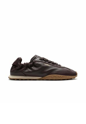 Zapatilla deportiva de cuero marrón oscuro con suela de goma, talón elástico, cordones trenzados y pequeño logo dorado "HOFF" en el lateral.