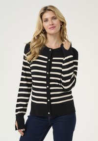 Juodos ir kreminės juostelės kardiganas su mygtukų uždarymu, ilgos rankovės ir raukšlėtos rankogaliai, pagamintas iš minkštos mezgimo medžiagos.