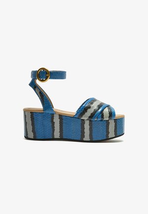 Blue platform sandals with a textured finish, featuring gray and black stripes. Adjustable ankle strap with a gold buckle detail.