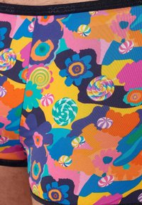 Färgglada kalsonger av boxer-modell tillverkade av stretchigt tyg, med ett livfullt blommigt och godissnurr-mönster i blå, rosa, gul och grön nyanser.