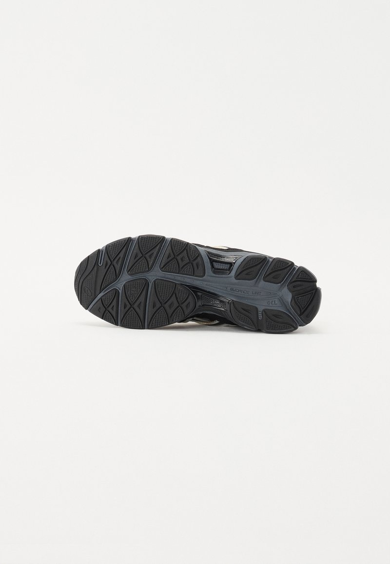 Schwarze sportliche Schuhsohle aus strukturiertem Gummi, mit multidirektionalen Rillen und einer unterstützenden Zwischensohle für Traktion und Komfort.