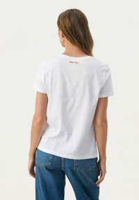 Witte katoenen t-shirt met korte mouwen en een ronde halslijn, voorzien van de tekst "Part Two" in rode borduursel op de bovenrug. Relaxte pasvorm.