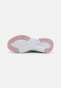 Suola di scarpa da ginnastica bianca con gommini rosa sul tallone e sulla punta, con un motivo di battistrada testurizzato, su uno sfondo bianco uniforme.