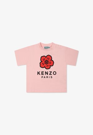 T-shirt rosa a maniche corte con scollatura tonda, caratterizzato da una grafica floreale rossa e il testo nero "KENZO PARIS". Materiale in cotone morbido, vestibilità casual.