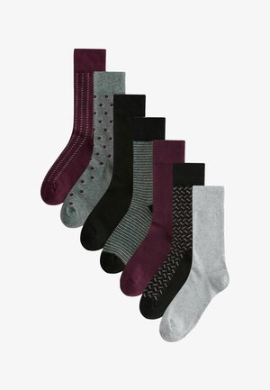 Sieben Paar Socken: verschiedene Farben (Grau, Schwarz, Burgunder) und Muster, einschließlich Streifen und Punkten, mit unterschiedlichen Texturen und Designs.