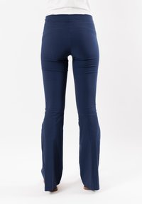 Pantaloni svasati blu navy realizzati in tessuto elasticizzato, con vita alta e una superficie liscia, e orli svasati nella parte inferiore.