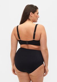 Ensemble de bikini noir avec des bretelles réglables et un bas taille haute. Texture lisse avec un minimum de matériel et un design simple.