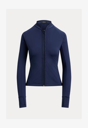 Γυναικείο στενό σακάκι σε ναυτικό μπλε χρώμα με μακριά μανίκια, φερμουάρ στο μπροστινό μέρος, γιακά τύπου mock neck και τρύπες για τον αντίχειρα στα μανίκια.