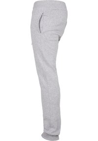 Grå bomullsjoggingbyxor med slim fit, elastisk midja, sidofickor och ribbad mudd. Slät textur och enkel design.