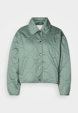 Καπιτονέ κοντό μπουφάν σε απαλό πράσινο, με κλασικό γιακά, κουμπιά με κλίπ και πλαϊνές τσέπες με υφή κυματιστού σχεδίου.