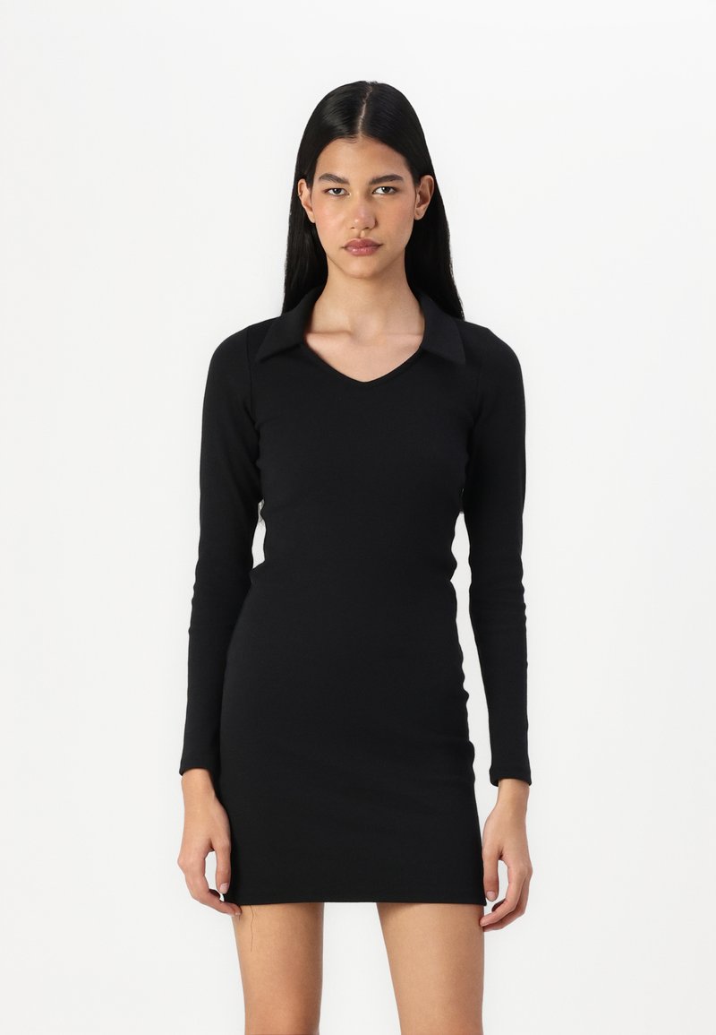 Μαύρο φόρεμα μακρυμάνικο με εφαρμοστή γραμμή, V-λαιμόκοψη και μυτερό γιακά. Φτιαγμένο από λείο ύφασμα, φτάνει μέχρι το μεσοφόρι.