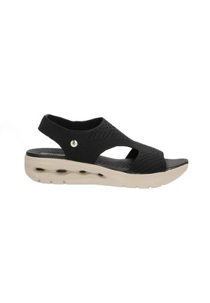 Sandalia negra de punta abierta con un upper texturizado y transpirable y una suela contorneada beige que cuenta con orificios de ventilación para mayor comodidad.