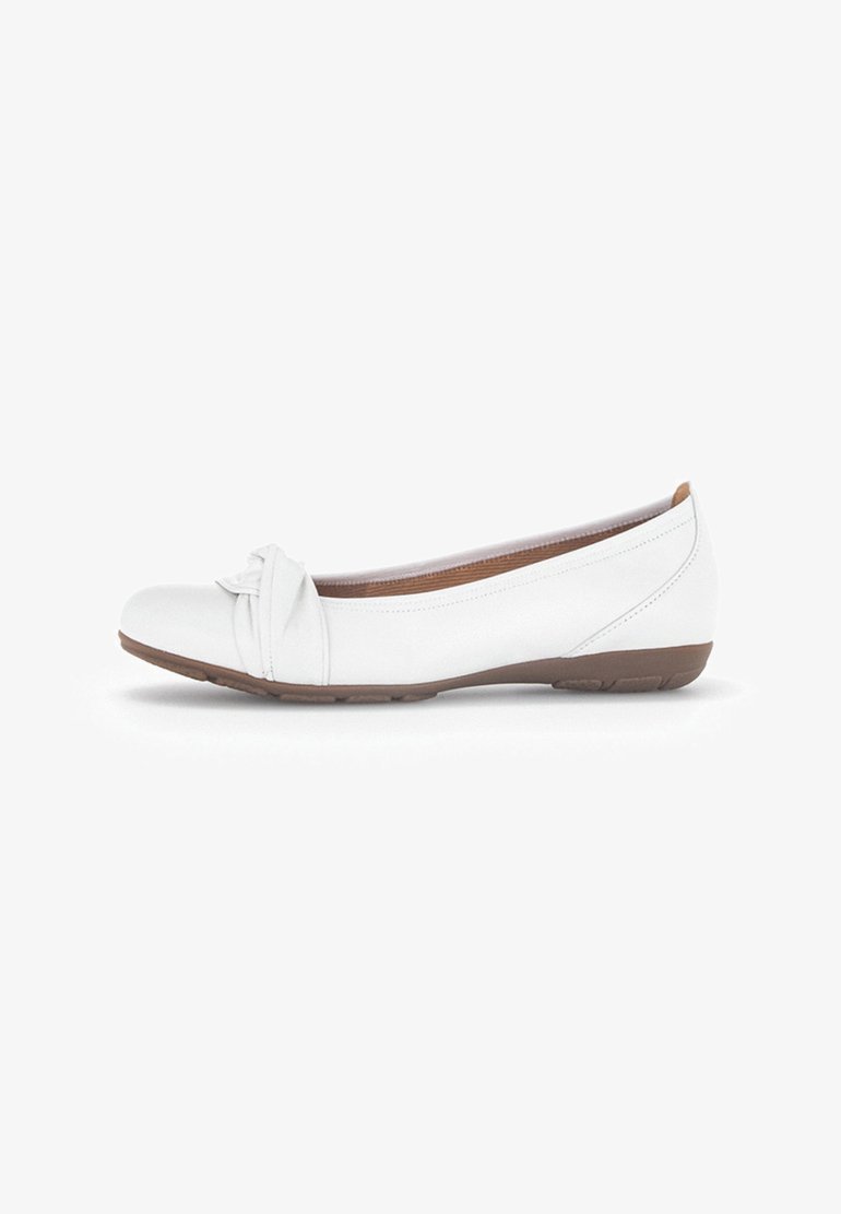 Bailarinas blancas con punta redondeada, detalle anudado en la parte delantera y suela de goma marrón. Material de cuero suave con costuras mínimas.