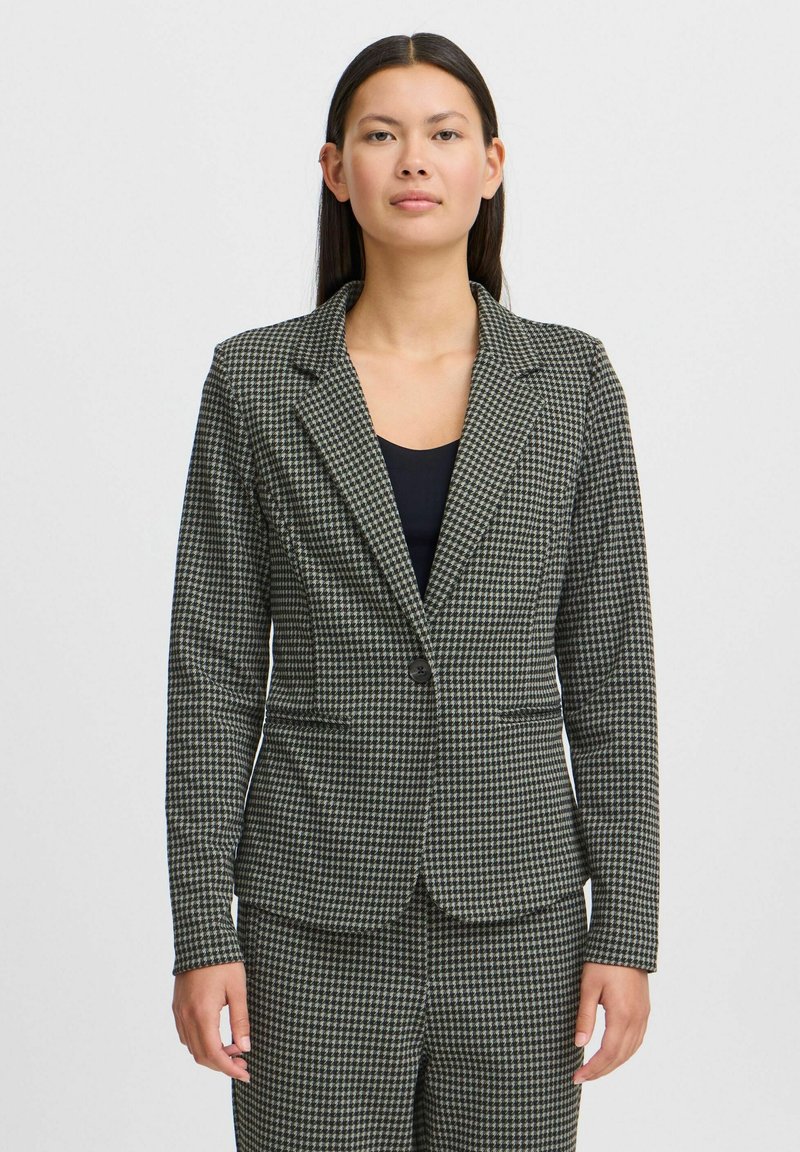 Pilkas ir juodas houndstooth raštas švarkas su prigludusia forma, nužybumu, viena mygtukų uždarymo sistema ir dviem priekinių kišenėmis.
