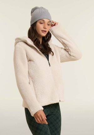 Giacca a felpa con cappuccio in morbido crema con chiusura a zip, caratterizzata da una vestibilità comoda e una superficie texturizzata; abbinata a un berretto in maglia grigia.