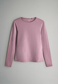 Halenka s dlouhým rukávem z jemné růžové látky, s kulatým výstřihem a volnějším střihem. Hladká textilie s minimálními švy.