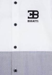 Camicia con bottoni, metà superiore bianca e metà inferiore grigia con texture, dotata di bottoni neri e del logo Bugatti "EB" in nero.