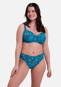 Conjunto de lencería de encaje en color teal que incluye un sujetador con escote en picos y tirantes ajustables, además de unas braguitas tipo hipster a juego con patrones florales y un detallado intrincado.