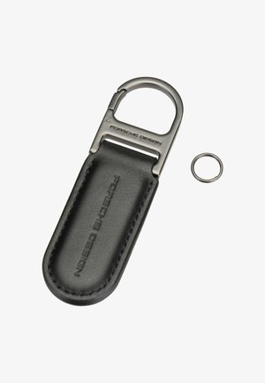 Porte-clés en cuir avec clip en métal gravé "Porsche Design" et anneau porte-clés en métal séparé sur fond blanc.