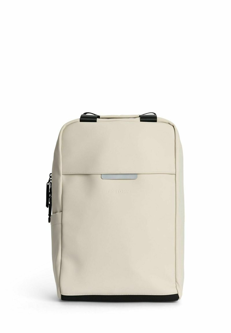 Beige reppu sileällä pinnalla ja mustilla yksityiskohdilla. Varustettu kaksoiskädensijalla, etutaskulla ja minimalistisella muotoilulla.