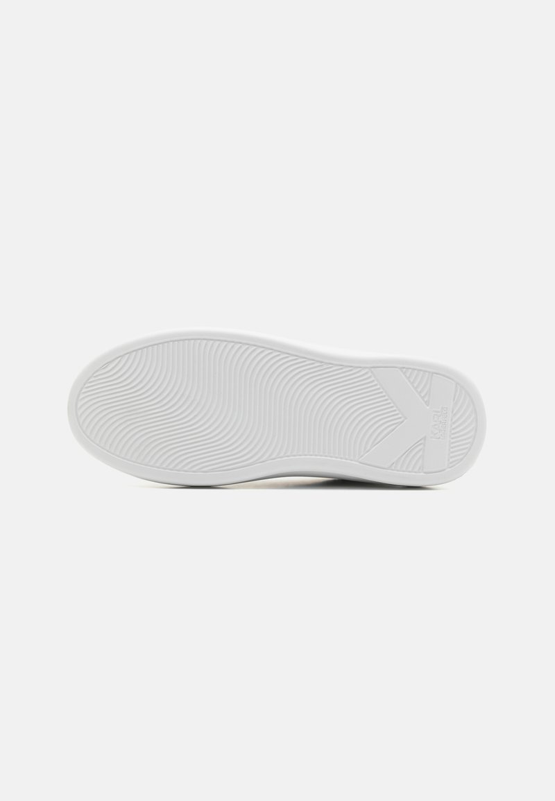 Suela de zapato de goma blanca con textura ondulada y logotipo elevado. Patrones circulares y lineales visibles en la superficie. Bordes redondeados.