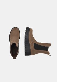 Brune ruskind ankelstøvler med en struktureret sort elastisk sidepanel og en kraftig sort gummisål med lagdelte skridsikre mønstre.