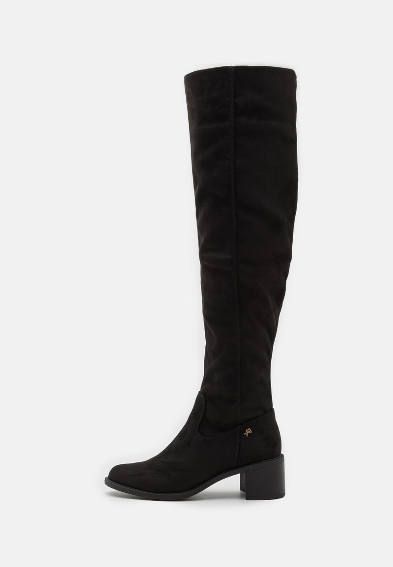 Black over-the-knee boot made of soft suede, featuring a block heel and side panel without visible fasteners. Smooth texture and fitted design.
